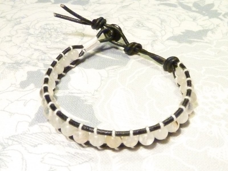 Chan Luu : cuoio nero e filo di cotone, perline in pietra di luna bottone  in metallo